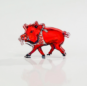 Red pig figurine with a silver belt on a white background