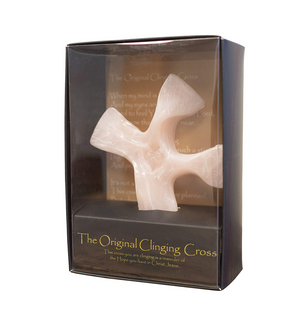 White cross-shaped object in a clear packaging box with text on a white background
